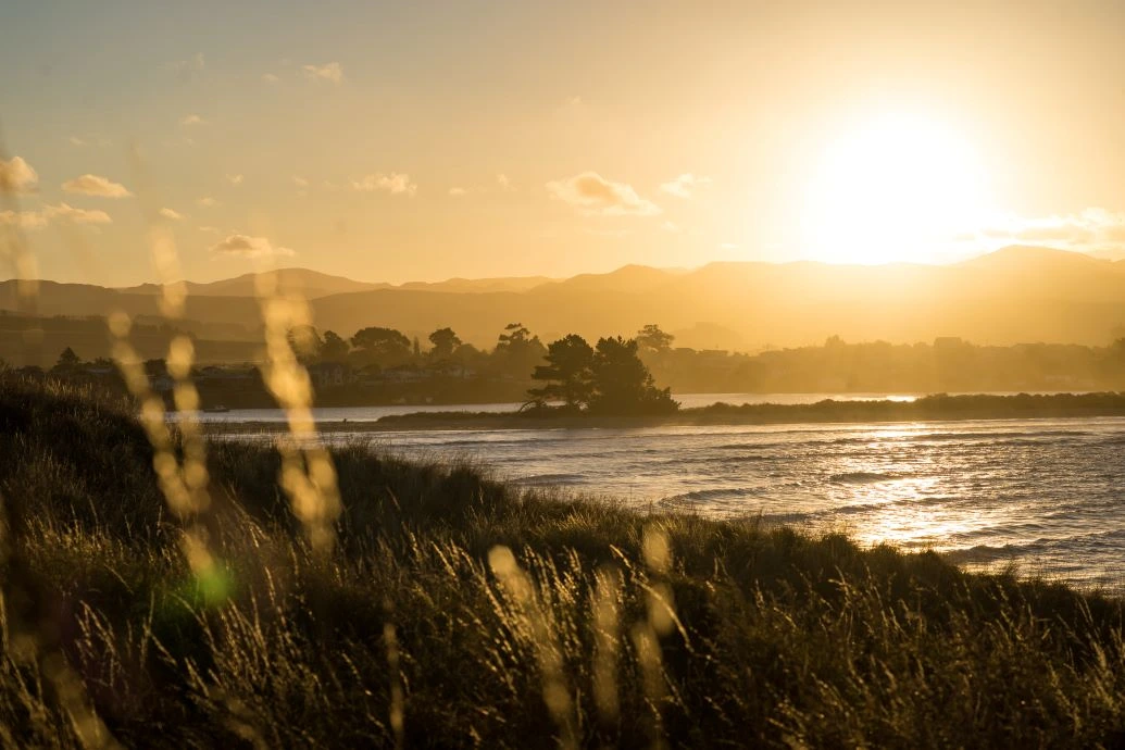 The hills and beach of Karitane at sunset.