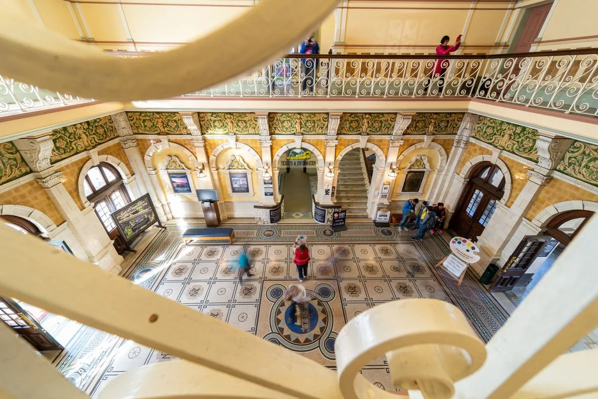 People walk the interior central atrium of the Dunedin Railway Station.