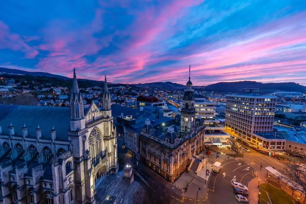 Dunedin's gothic heritage buildings under a purple sunrise.