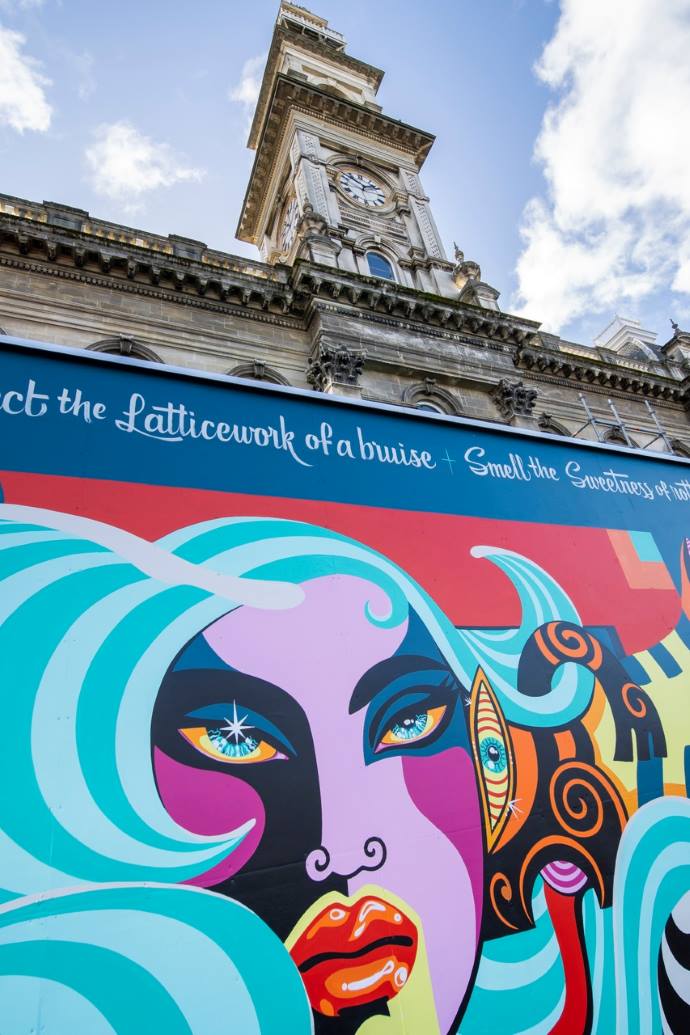Street Art Trail Chambers The Dunedin Municipal Chambers clocktower and the street art hoarding around its base.