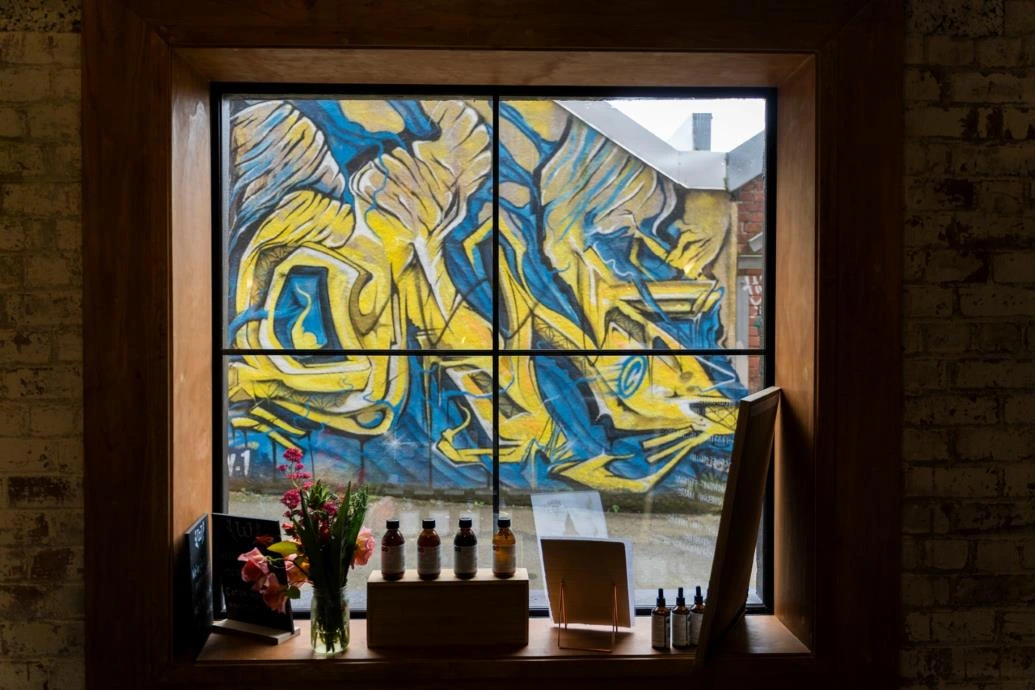 Street Art Trail Wild Dispensary Blue and yellow street art seen through the window of Wild Dispensary.